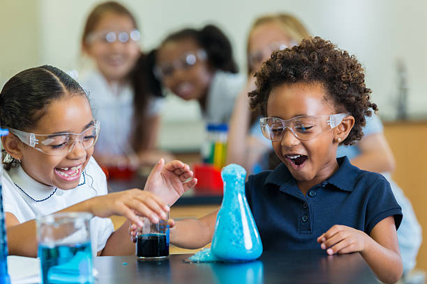Children wearing safety goggles exploring a bubbling science experiment
