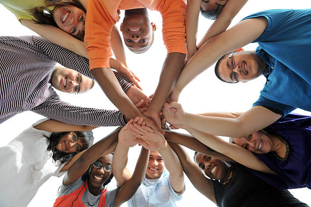 A team reaching into a shared circle of hands